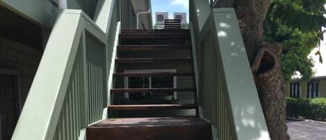 A staircase with green railings leading to an upper level.