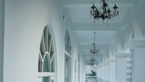 A long, white corridor with arched windows and a chandelier. - Empire Pacific Castle (Taoyuan City)