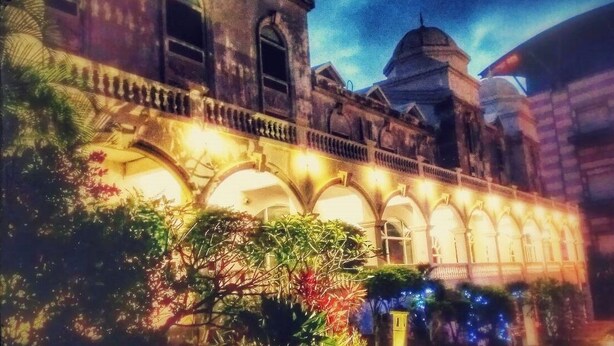 A historic building with arched windows and a balcony, illuminated by warm lighting. - Empire Pacific Castle (Taoyuan City)