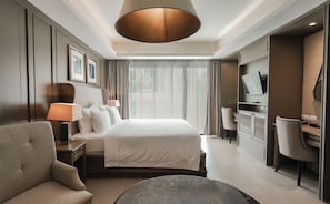 Une chambre d’hôtel équipée d’un lit, d’un bureau, d’une chaise, d’une télévision et d’une lampe.