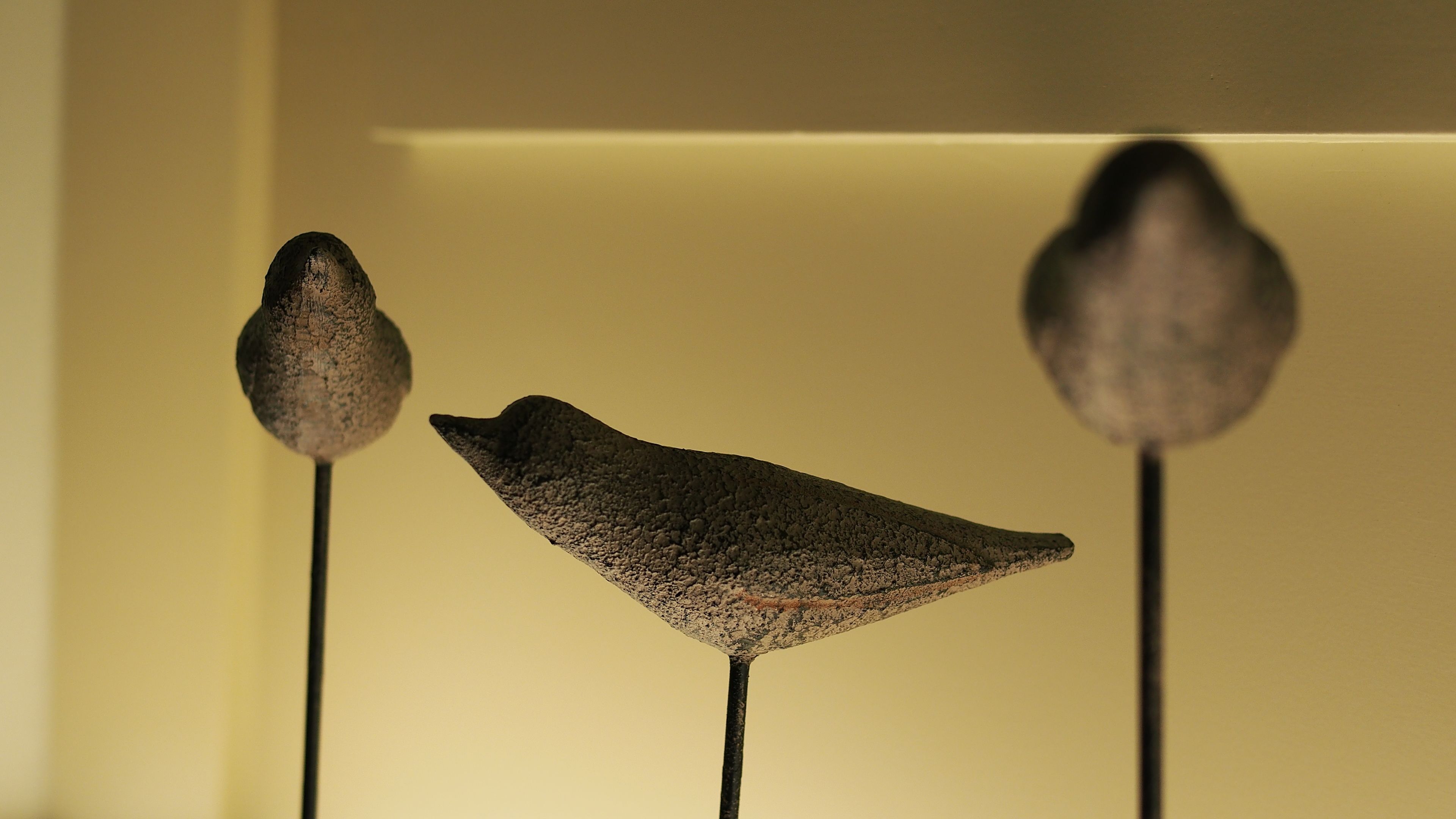 Three bird-shaped sculptures on metal poles.
