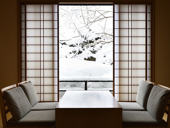 A room with a view of a snowy landscape through a shoji screen.
