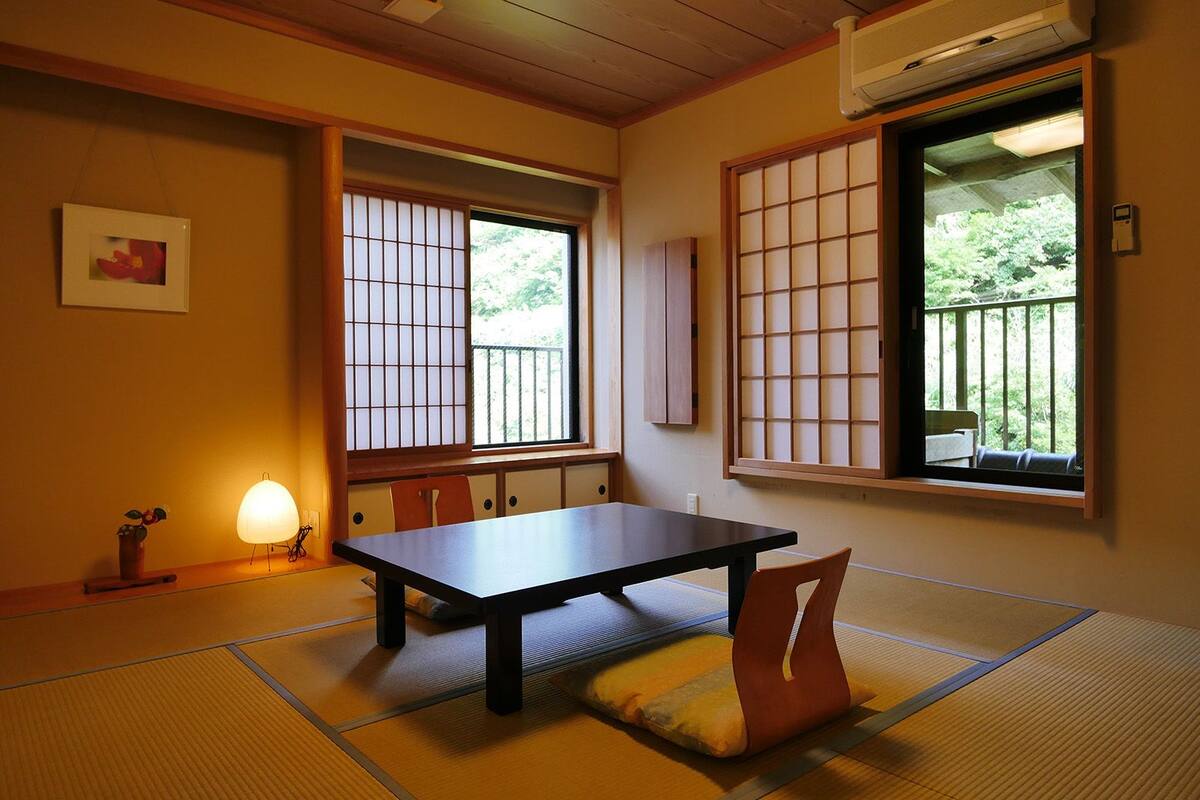 A traditional Japanese room with tatami flooring, a low table, and sliding shoji doors.