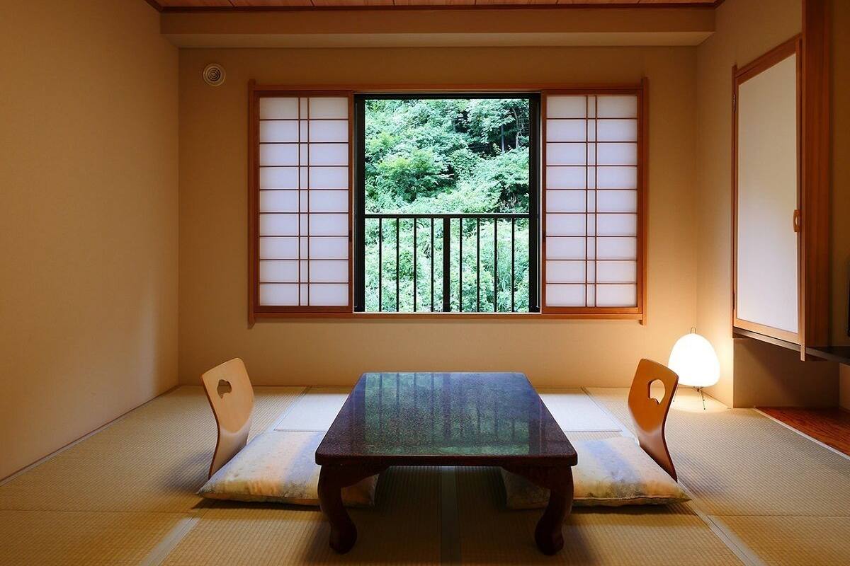 A traditional Japanese room with tatami flooring, a low table, and sliding shoji doors.