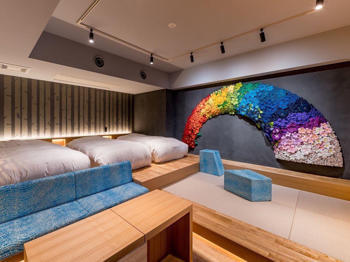 A modern room with a curved wall mural, a sofa, a bed, and a wooden table.