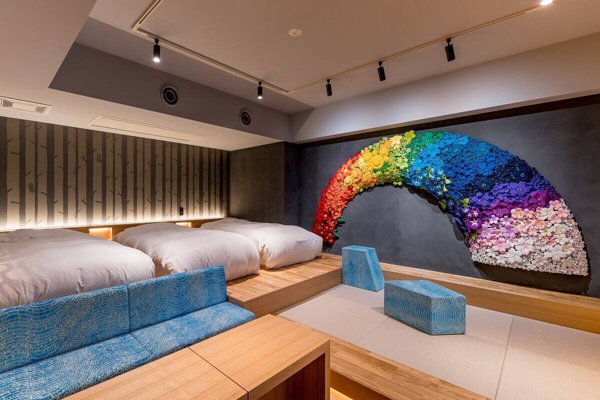 A modern room with a curved wall mural, a sofa, a bed, and a wooden table.