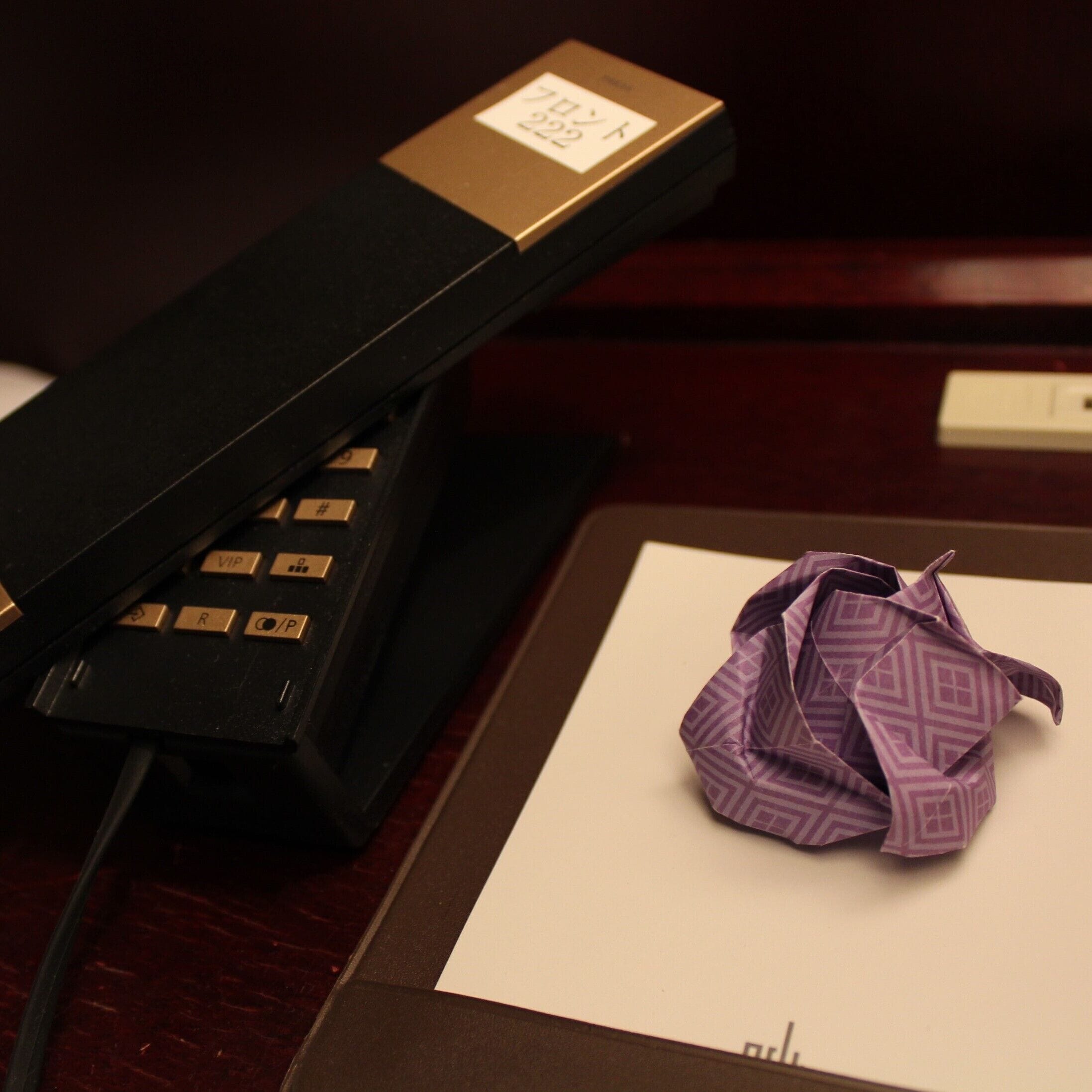 A desk with a telephone and a crumpled piece of paper.