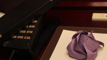 A desk with a telephone and a crumpled piece of paper.