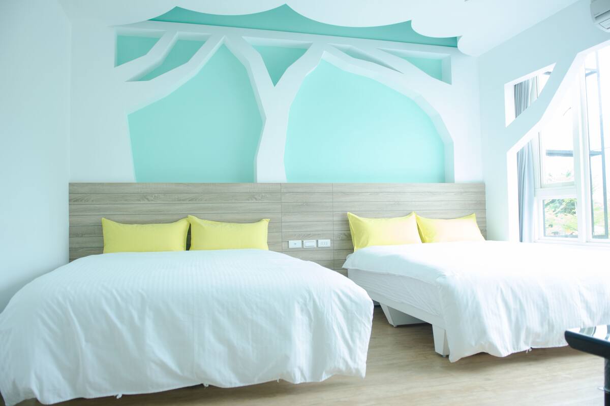 A hotel room with two beds, a wooden headboard, and a ceiling with a tree-like design.