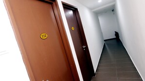 A corridor with two doors, each marked with a number. - Hotel Al Abraar (Malacca City)