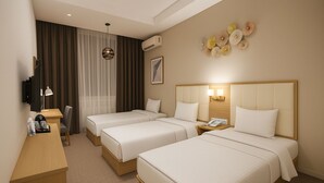 A hotel room with two beds, a desk, a chair, a TV, and a wall-mounted air conditioner. - Sayyoh Hotel (Tashkent)
