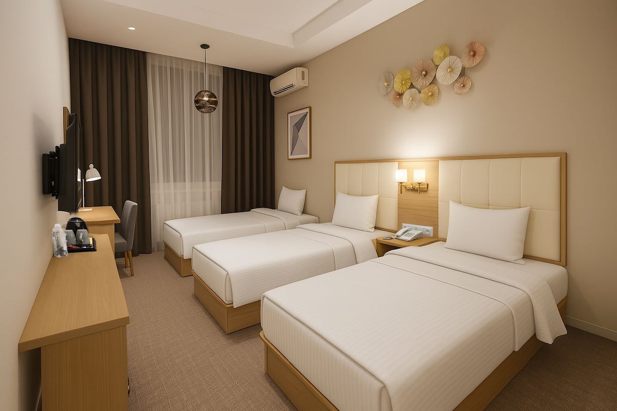 A hotel room with two beds, a desk, a chair, a TV, and a wall-mounted air conditioner.
