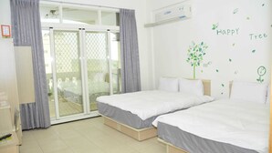 A hotel room with two beds, a sliding glass door to the balcony, a wardrobe, and a wall decoration saying "Happy Tree". - tai-chia Bed and Breakfast (Jincheng)