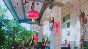 A covered outdoor area with a tiled floor, wooden benches, and potted plants. - tai-chia Bed and Breakfast (Jincheng)