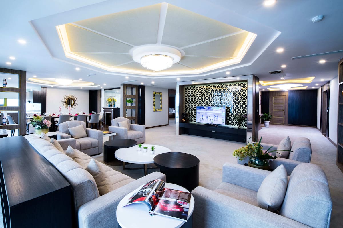A modern hotel lobby with a seating area, a coffee table with magazines, and a decorative wall.