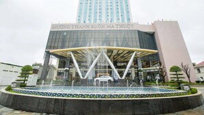 A modern building with a large entrance and a fountain in front. - Muong Thanh Luxury Buon Ma Thuot (Tan An)