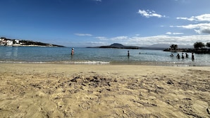 A beach with clear blue water, sandy shore, and distant hills. - Sk Place Crete Luxury Seafront Villas (Apokoronas)