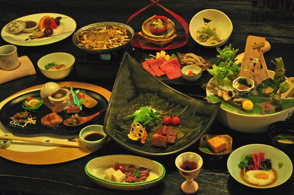 Una variedad de platos en una mesa, incluyendo sushi, sashimi y otras especialidades asiáticas.