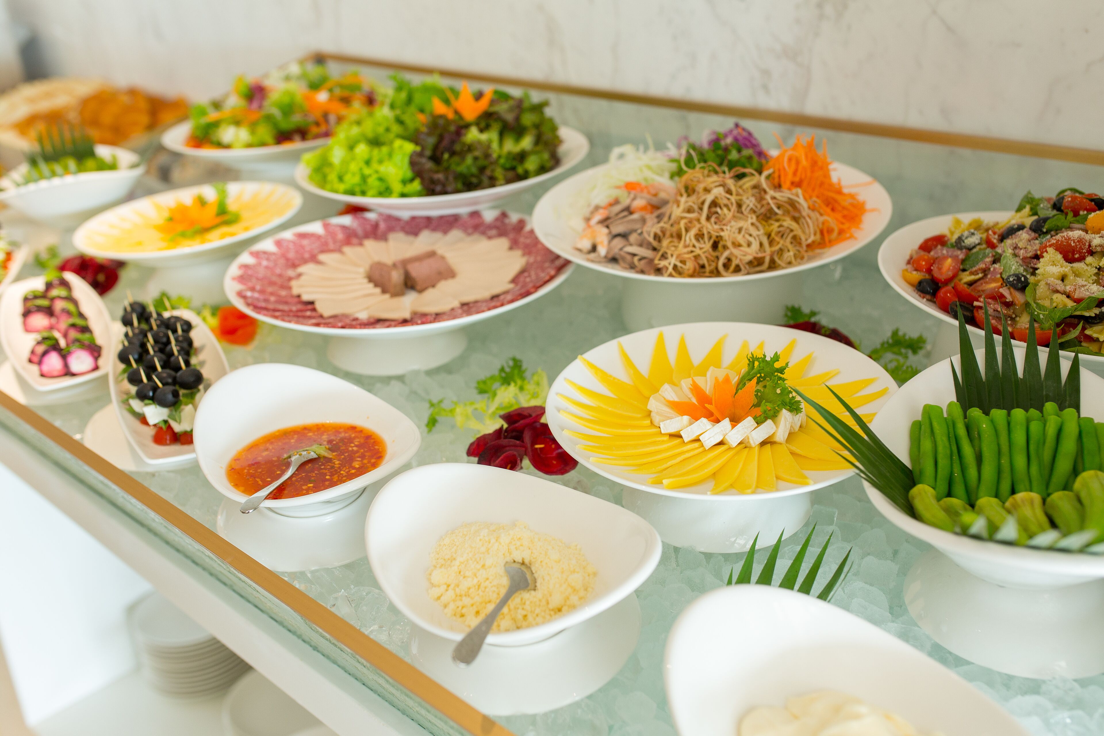 A buffet table with various dishes including salads, meats, and vegetables.