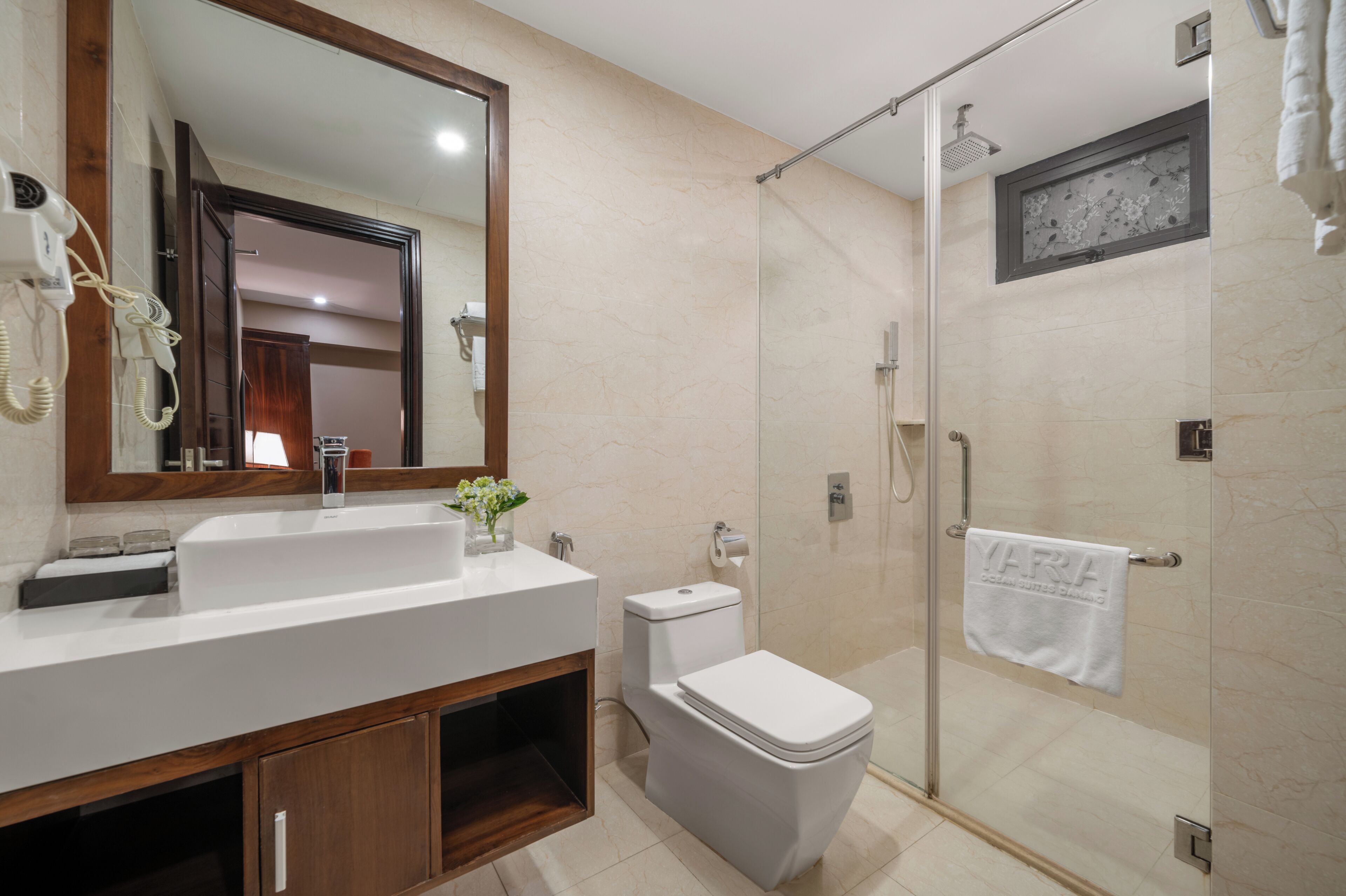 A bathroom with a white sink, mirror, toilet, and shower.