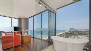 A modern bathroom with a large bathtub and a glass-enclosed shower area. - Yarra Ocean Suites Danang (Da Nang)