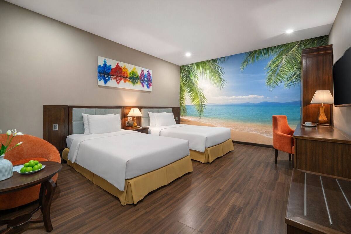 A hotel room with two beds, a desk, a chair, a painting, and a beach mural.