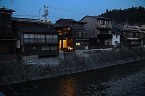 Une ville japonaise traditionnelle avec des escaliers en pierre menant à une rivière.