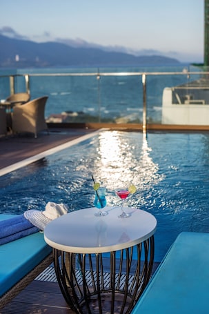 Una piscina al aire libre, sillones reclinables de piscina