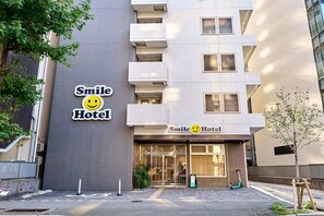 Un hotel con un letrero que muestra una carita sonriente y el nombre 'Smile Hotel'.