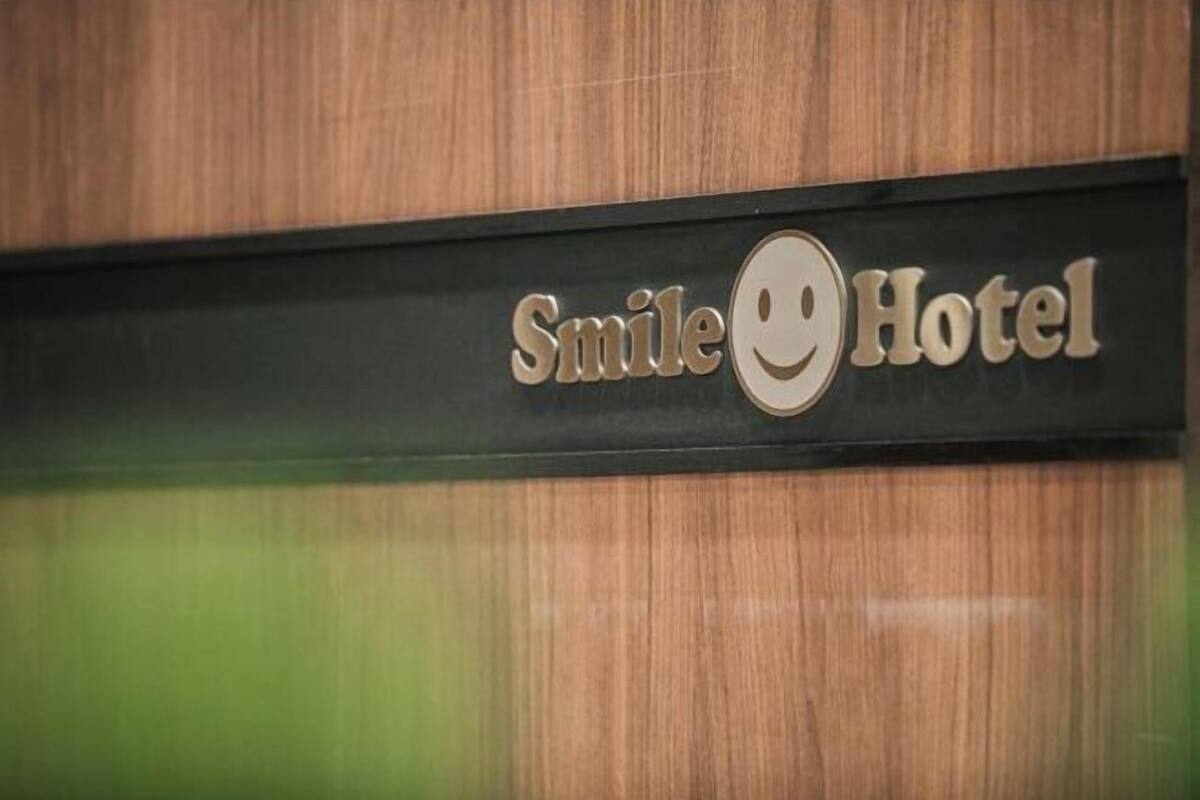 Une enseigne avec l’inscription « Smile Hotel » et un visage souriant.