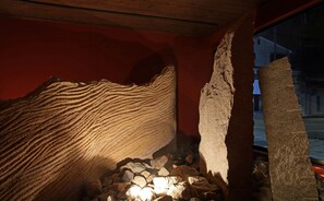 Un interior que recuerda a una cueva, con formaciones rocosas y techo de madera.