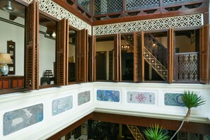 A traditional interior with wooden lattice windows, a staircase, and decorative tiles. - 5 Heeren (Malacca City)