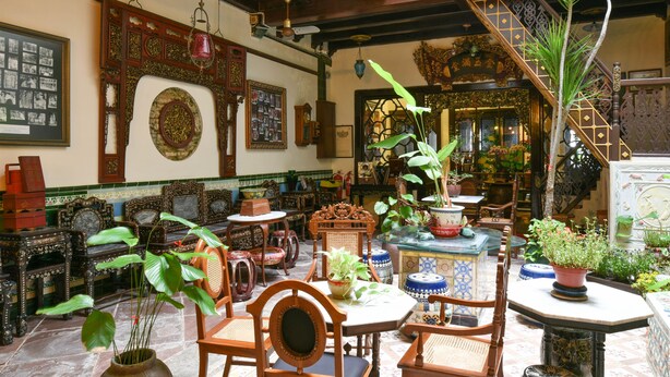 A traditional interior with ornate furniture, a staircase, and various decorative items. - 5 Heeren (Malacca City)