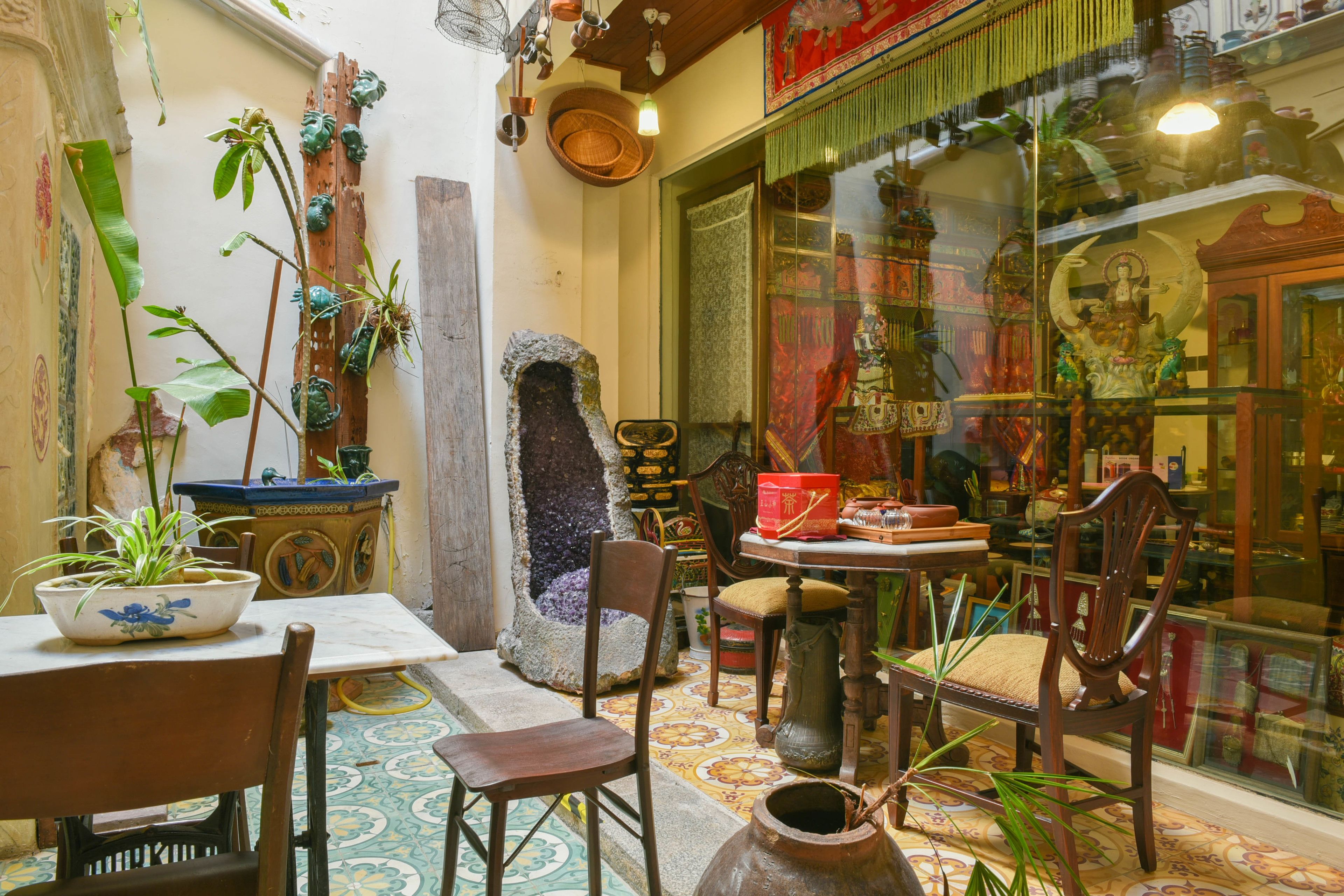 Ein traditionell eingerichtetes Interieur mit einem Kamin aus Stein, Holzmöbeln und einer Vitrine mit religiösen Artefakten.