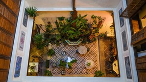 A room with a tiled floor, a wooden door, and a variety of potted plants. - 5 Heeren (Malacca City)