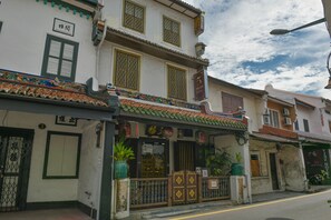 A traditional building with a tiled roof, a sign for the 5 Heeren Hotel, and a gate with decorative elements. - 5 Heeren (Malacca City)