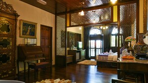 A traditional room with wooden furniture, a large mirror, and a decorative screen. - 5 Heeren (Malacca City)