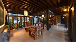 A spacious, well-lit wooden interior with a fireplace, seating area, and large windows.