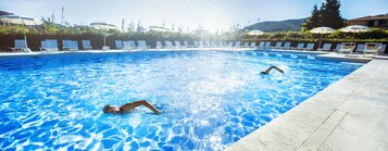 Una piscina al aire libre de temporada, sombrillas