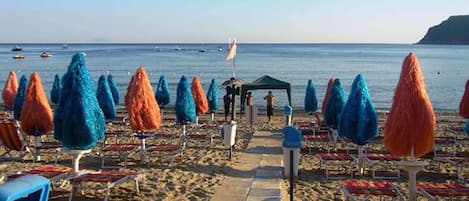 Aan een privéstrand, ligstoelen, parasols