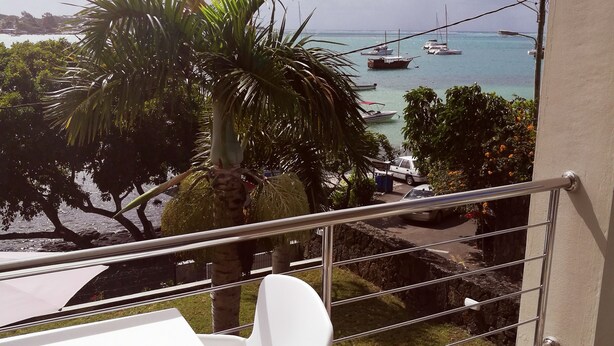A balcony with a white table and chairs, overlooking a marina with boats and a clear sky. - Valmarin Seafront Apartments (Trou d'Eau Douce)