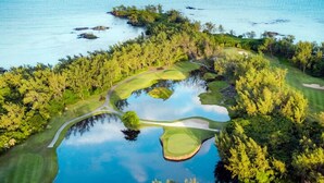 An aerial view of a golf course with water features and dense greenery. - Valmarin Seafront Apartments (Trou d'Eau Douce)