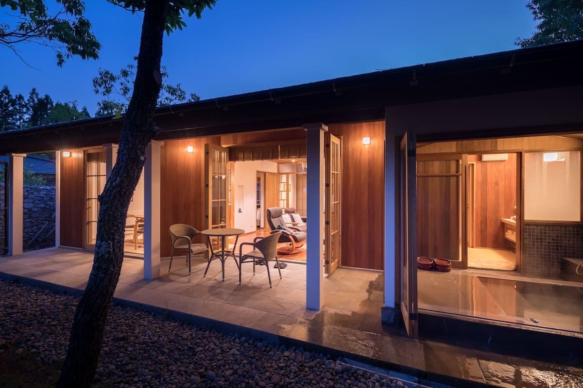 Una casa moderna con un patio, una mesa de comedor y un área de descanso.