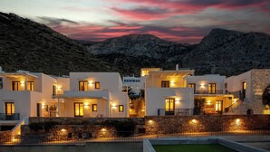 A modern villa with multiple white buildings, stone walls, and a pool area. - Sifnos House - Rooms & Spa (Sifnos)