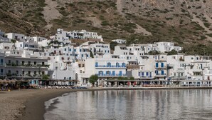 A coastal village with white buildings, a beach, and a hillside. - Sifnos House - Rooms & Spa (Sifnos)