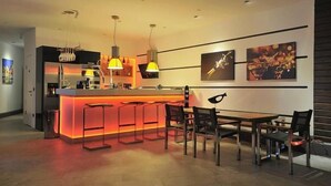 A modern kitchen with a central island, pendant lighting, and a dining area with a table and chairs. - Yahsi's Yahsi Resort Aparts (Bodrum)