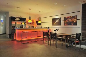 A modern kitchen with a central island, pendant lighting, and a dining area with a table and chairs. - Yahsi's Yahsi Resort Aparts (Bodrum)