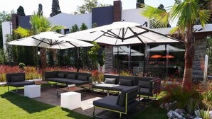 An outdoor patio with modern furniture, including sofas and a coffee table, under large umbrellas. - Yahsi's Yahsi Resort Aparts (Bodrum)