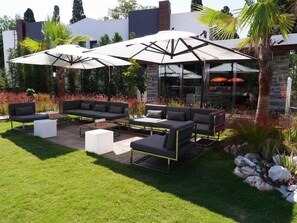 An outdoor patio with modern furniture, including sofas and a coffee table, under large umbrellas. - Yahsi's Yahsi Resort Aparts (Bodrum)