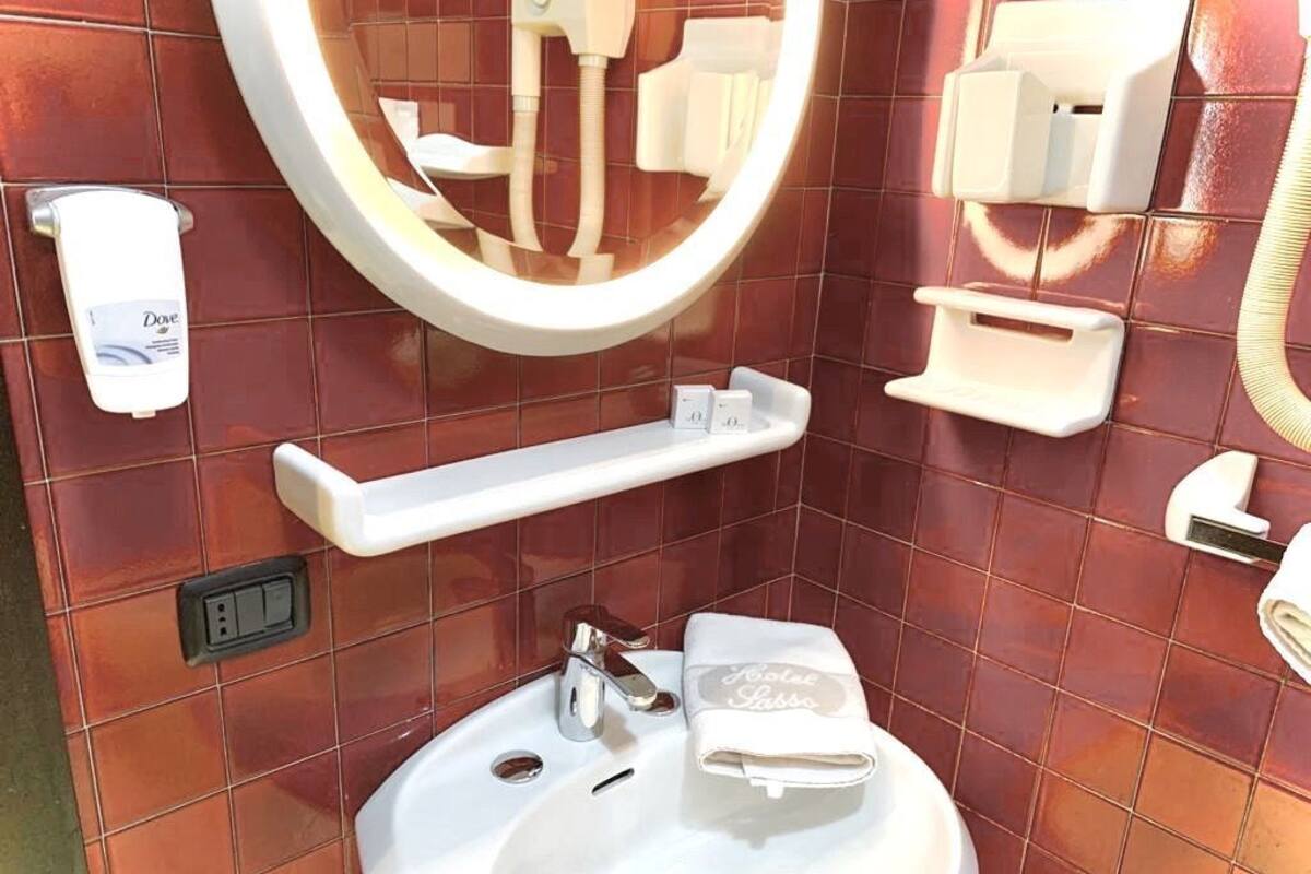 Ein Badezimmer mit Waschbecken, Spiegel und Handtuchhalter.